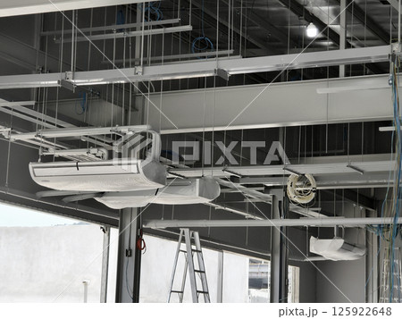 The ceiling of a large building under construction an extensive network of pipes 125922648