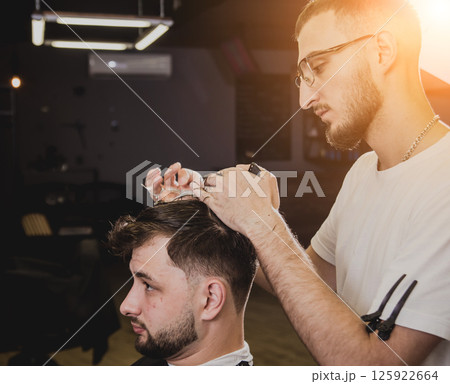 Young man with trendy haircut at barber shop. Young man with trendy haircut at barber shop. 125922664