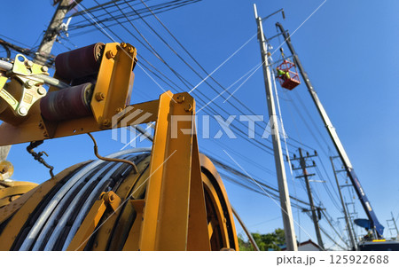 Installation of high-voltage electric wires on new poles along the road 125922688