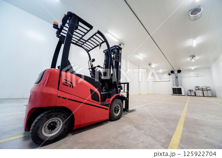 Forklift in a large industrial freezer warehouse. Forklift in a large industrial freezer warehouse. 125922704