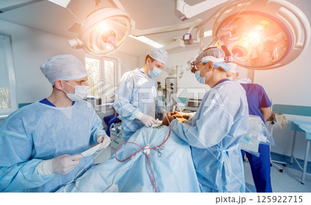 Spinal surgery. Group of surgeons in operating room with surgery equipment.  125922715
