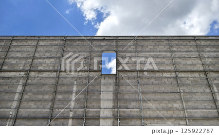 A brick wall with small window under construction A brick wall with small window under construction 125922787