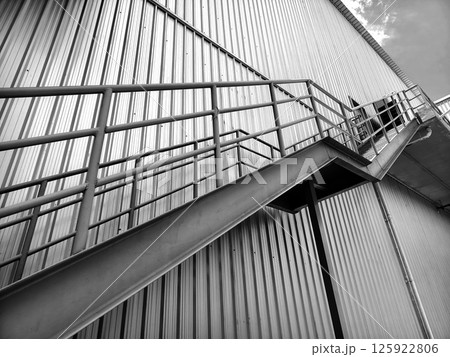 A set of stairs ascending a large black wall 125922806