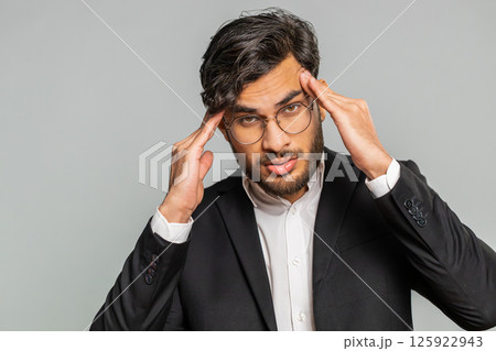 Indian man rubbing temples to cure headache problem, suffering from tension and migraine stress pain 125922943