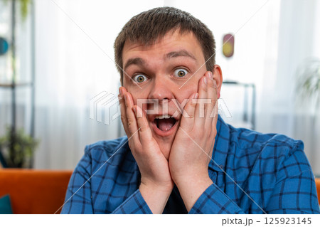 Excited shocked amazed young man surprised looking at camera with big eyes wow emotion good win news Excited shocked amazed young man surprised looking at camera with big eyes wow emotion good win news 125923145