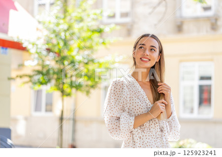 Thoughtful smiling happy young woman with pensive expression pondering a solution dreaming thinking Thoughtful smiling happy young woman with pensive expression pondering a solution dreaming thinking 125923241