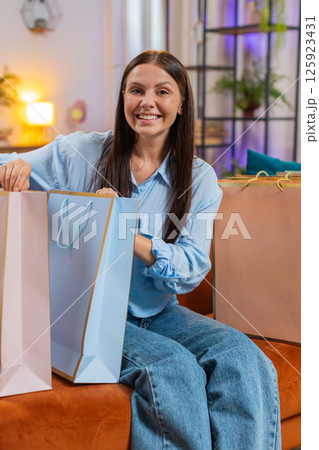 Happy woman shopaholic consumer came back home after shopping holiday sale in mall with paper bags Happy woman shopaholic consumer came back home after shopping holiday sale in mall with paper bags 125923431