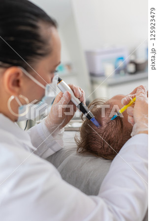 Trichologist doing man improve hair growth procedure, dermapen microneedling, vitamin injections Trichologist doing man improve hair growth procedure, dermapen microneedling, vitamin injections 125923479