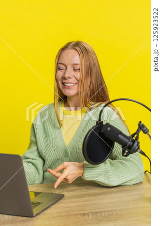 Woman blogger influencer recording podcast giving workshop webinar speaking in microphone and laptop Woman blogger influencer recording podcast giving workshop webinar speaking in microphone and laptop 125923522