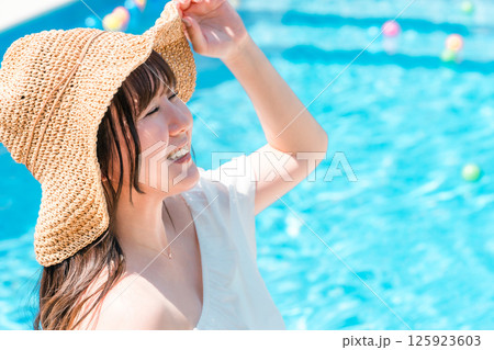 プールサイドで日光浴する若いアジア人女性 プールサイドで日光浴する若いアジア人女性 125923603