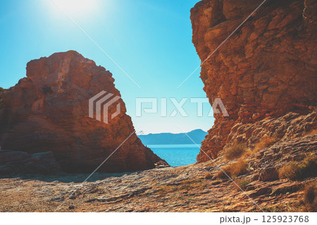 Rocky seascape on a sunny day. Seascape in daylight. View of the sea between two rocks Rocky seascape on a sunny day. Seascape in daylight. View of the sea between two rocks 125923768