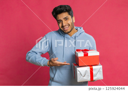 Smiling man presenting birthday gift present box stretches out hands, promotion discount sale 125924044