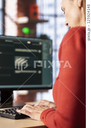 Mature woman interacting with a virtual assistant on her computer at home office, AI generated responses and smart automation to improve online communication. Data driven solutions. 125924148