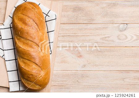 freshly baked bread with napkin on rustic table top view. Healthy white bread loaf isolated 125924261
