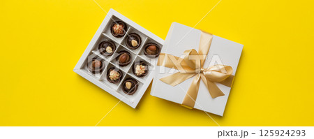 White box with chocolates candies and golden tape. top view with copy space 125924293