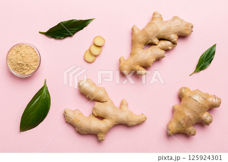 Finely dry Ginger powder in bowl with green leaves isolated on colored background. top view flat lay 125924301