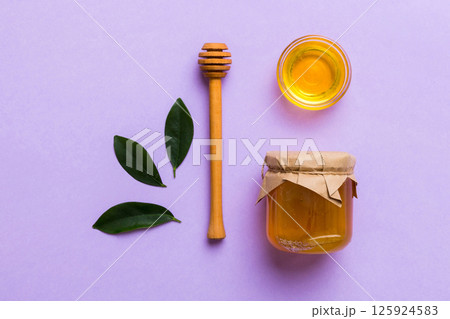 Honey jar with wooden honey dipper on white background top view with copy space. Delicious honey bottle Honey jar with wooden honey dipper on white background top view with copy space. Delicious honey bottle 125924583