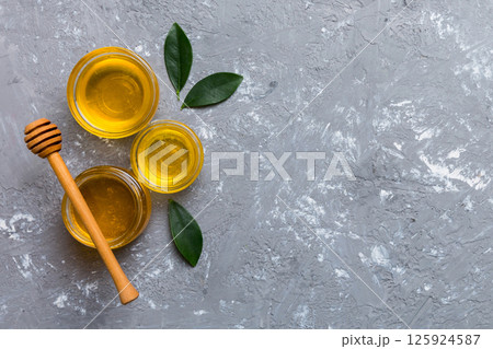 Honey jar with wooden honey dipper on white background top view with copy space. Delicious honey bottle Honey jar with wooden honey dipper on white background top view with copy space. Delicious honey bottle 125924587