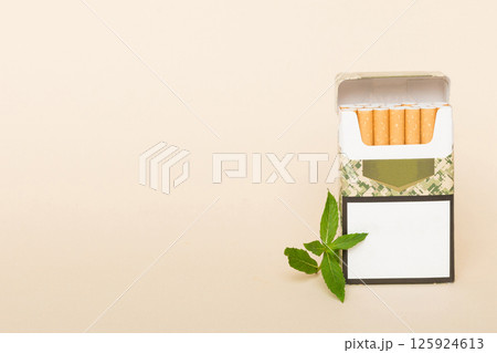 Pack of menthol cigarettes and fresh mint on colored table, Menthol cigarettes top view flat lay Pack of menthol cigarettes and fresh mint on colored table, Menthol cigarettes top view flat lay 125924613