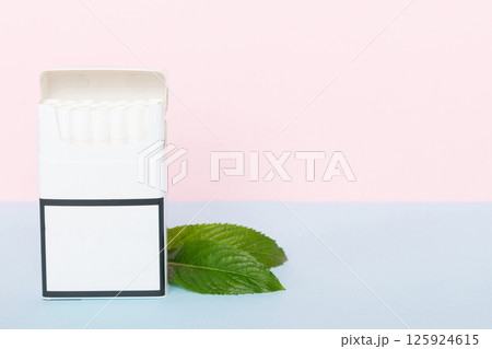 Pack of menthol cigarettes and fresh mint on colored table, Menthol cigarettes top view flat lay Pack of menthol cigarettes and fresh mint on colored table, Menthol cigarettes top view flat lay 125924615