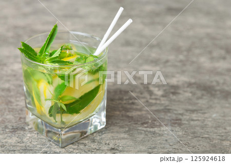 Mojito cocktail. Refreshing mojito cocktail with lime, lemon and mint in a tall glass with a stick 125924618