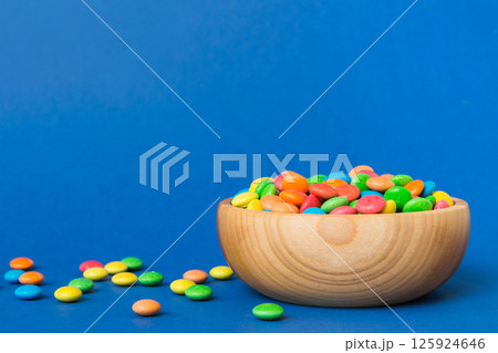 Multicolored candies in a bowl on a colored background. birthday and holiday concept. Top view with copy space Multicolored candies in a bowl on a colored background. birthday and holiday concept. Top view with copy space 125924646