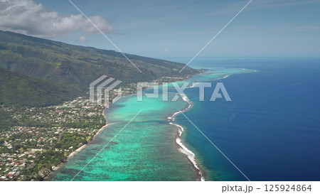 Aerial drone captures the stunning coastline of Tahiti island, showcasing the vibrant turquoise coral reef, lush green mountains, cityscape village and the vast expanse of the pacific ocean Aerial drone captures the stunning coastline of Tahiti island, showcasing the vibrant turquoise coral reef, lush green mountains, cityscape village and the vast expanse of the pacific ocean 125924864