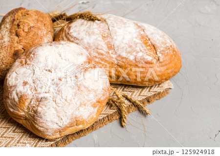 Homemade natural breads. Different kinds of fresh bread as background, perspective view with copy space Homemade natural breads. Different kinds of fresh bread as background, perspective view with copy space 125924918