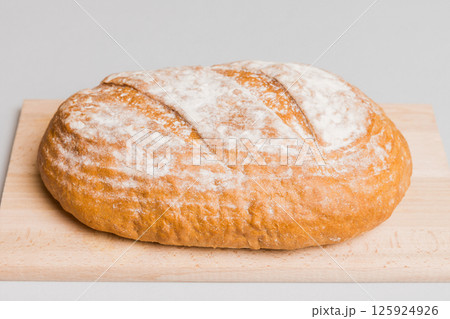Freshly baked bread on cutting board against white wooden background. perspective view bread with copy space Freshly baked bread on cutting board against white wooden background. perspective view bread with copy space 125924926