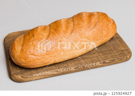 Freshly baked bread on cutting board against white wooden background. perspective view bread with copy space 125924927