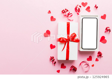 Opened gift box with ribbon and phone on color background, top view. Blank open box packaging mockup , Template for your design - branding mockup 125924965