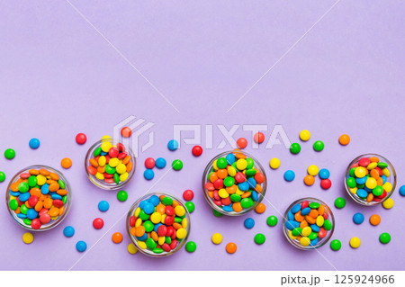 different colored round candy in bowl and jars. Top view of large variety sweets and candies with copy space 125924966