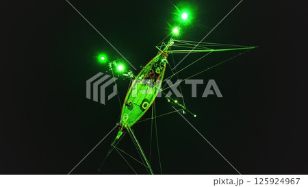 Low angle night view of a squid fishing boat using green lights to attract its prey, creating a surreal atmosphere in the darkness off the coast of Koh Phangan, Thailand 125924967