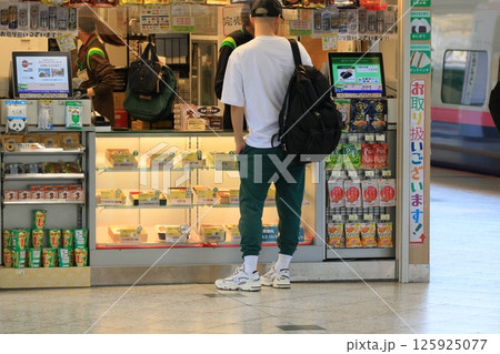 ホームのキオスクで買い物をする乗客　駅のキオスク 125925077