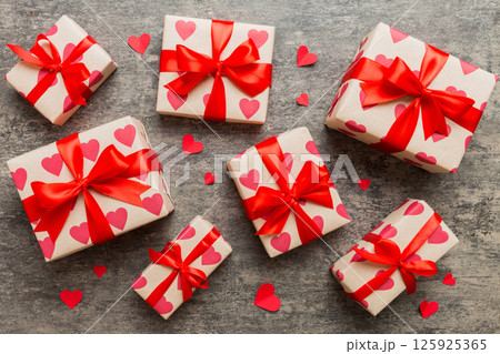 Top view photo of valentine day decorations gift box with red ribbon bow on colored background. Holiday gift boxes with top view 125925365