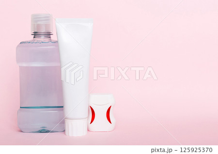 Mouthwash and other oral hygiene products on colored table top view with copy space. Flat lay. Dental hygiene. Oral care products and space for text on light background. concept Mouthwash and other oral hygiene products on colored table top view with copy space. Flat lay. Dental hygiene. Oral care products and space for text on light background. concept 125925370