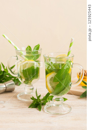 Mojito cocktail. Refreshing mojito cocktail with lime, lemon and mint in a tall glass with a stick 125925443