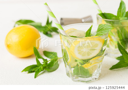 Mojito cocktail. Refreshing mojito cocktail with lime, lemon and mint in a tall glass with a stick Mojito cocktail. Refreshing mojito cocktail with lime, lemon and mint in a tall glass with a stick 125925444