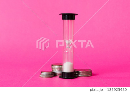 Deadline and time is money concept with hourglass and US coins currency. sand clock time for saving concept Deadline and time is money concept with hourglass and US coins currency. sand clock time for saving concept 125925480