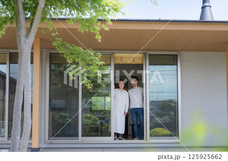 緑のある家の縁側や縁の下で庭を眺める夫婦　カメラ目線 125925662