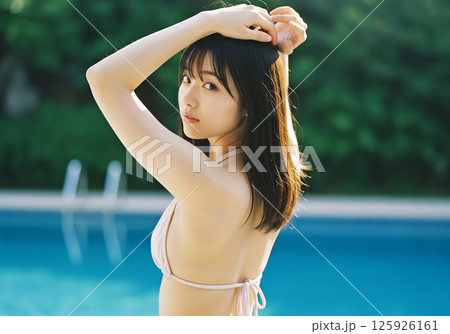 プールサイドで過ごす若い女性 125926161