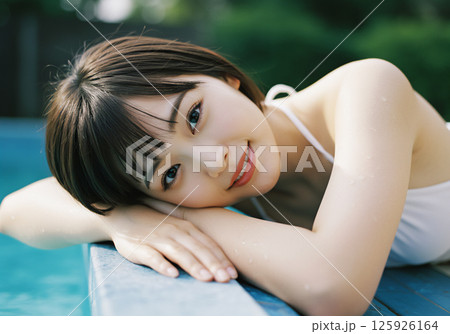 プールサイドで過ごす若い女性 125926164