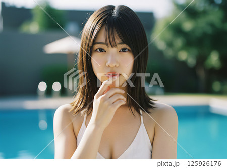 プールサイドで過ごす若い女性 125926176