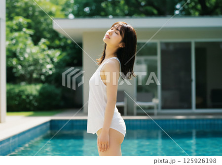 プールサイドで過ごす若い女性 125926198