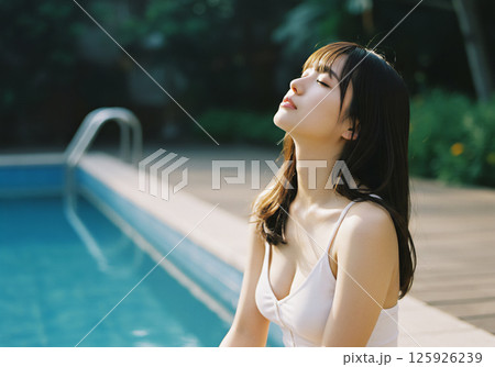 プールサイドで過ごす若い女性 125926239