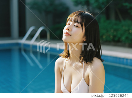 プールサイドで過ごす若い女性 125926244