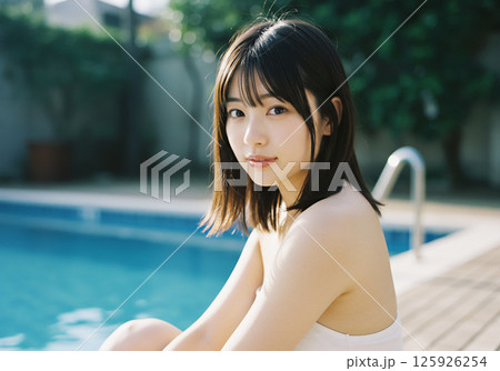 プールサイドで過ごす若い女性 125926254