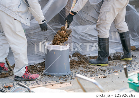 下水道工事　土砂を土のうに詰める土木作業員 125926268