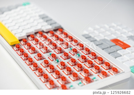 Red mechanical keyboard switches exposed, showing hot-swappable design for customization 125926682