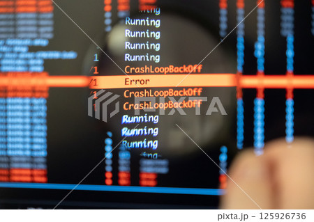 Man's hand holds magnifying glass over screen showing CrashLoopBackOff and Error messages, symbolizing focused debugging work 125926736